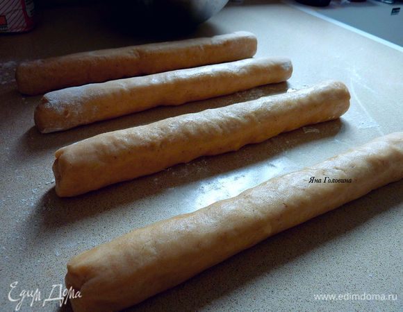 Убрать в холодильник на 30 минут . 

Разогреть духовку на 180 гр 

На слегка припыленной мукой поверхности раскатать каждую часть в колбаску 25 см. 
