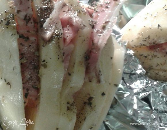  На картофеле сделать  3-4 глубоких  надреза, но не до конца. Посолить (немного т.к. бекон может быть достаточно соленый), поперчить,  между разрезами положить бекон, сверху немного взбрызнуть растительным маслом, посыпать сухими травами (травы могут быть любые базилик, орегано и т.д.).Как вариант можно положить листики свежего шафрана (на мой взгляд отличное сочетание).