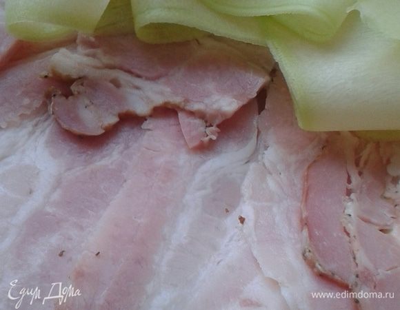 Бекон нарезать тонкими ломтиками. Кабачок почистить и нарезать овощечисткой, так, чтобы получились тонкие "лепестки".