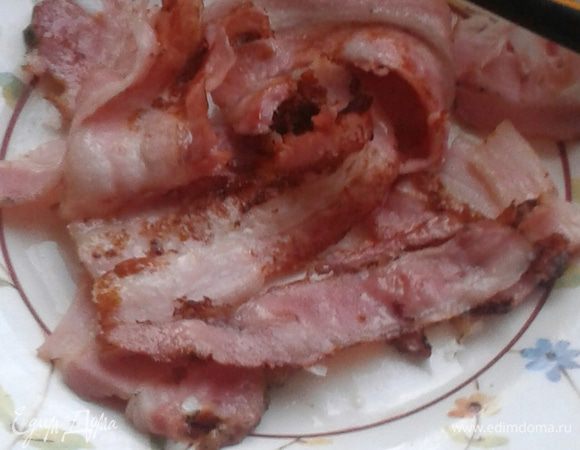 Тонкие полоски бекона обжарить до прозрачности, добавив на сковородку немного оливкового масла.