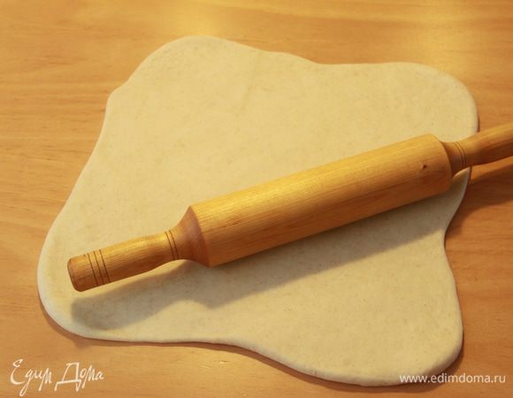 Рабочую поверхность подпылить мукой, выложить тесто, раскатать его в квадрат.