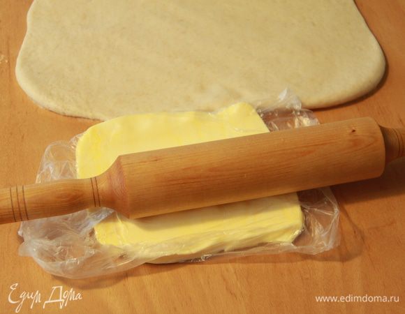 Охлаждённое сливочное масло раскатать скалкой через плёнку.
