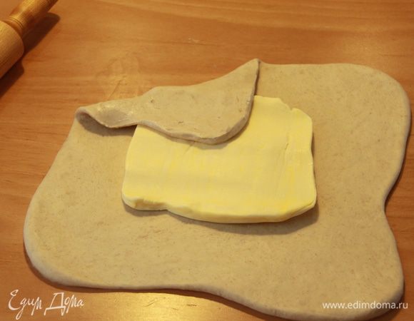 В центр теста выложить масло, накрыть масло концами теста.