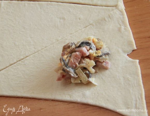 Начинку положить на треугольник теста ближе к широкому краю, завернуть в виде рогалика.