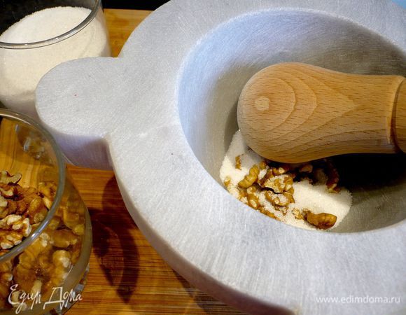 Тем временем готовим начинку. Добавляя попеременно в ступку то орехи, то сахар, растираем начинку в крошку.
