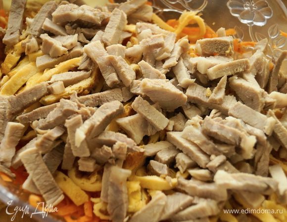 К морковке добавить нарезанное мясо и яичные блинчики, добавить мелко порубленный или выдавленный через пресс чеснок.