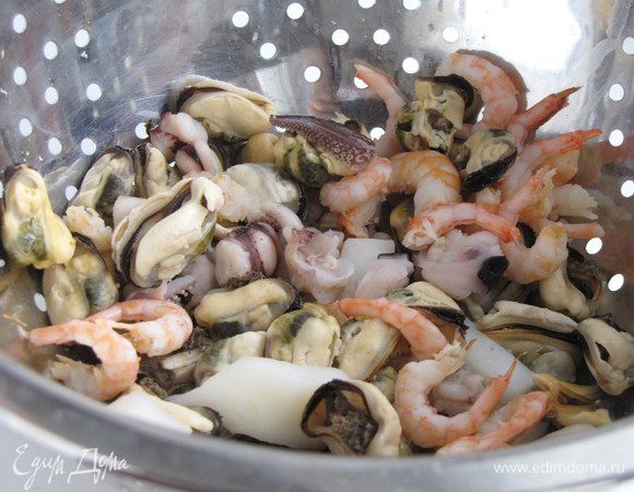 Морской коктейль разморозить, переложить в небольшую кастрюльку, влить вино и готовить, пока вино полностью не выпарится, примерно 5 минут. Снять с огня и отставить.