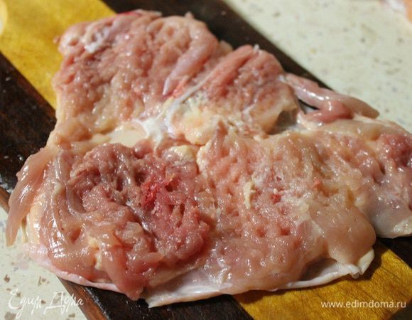 У куриного окорочка вырезать кость и слегка отбить полученное филе.