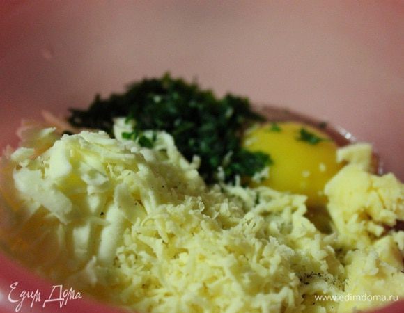 Оставшийся сыр натереть на крупной терке, добавить к нему перец, зелень и яйцо.