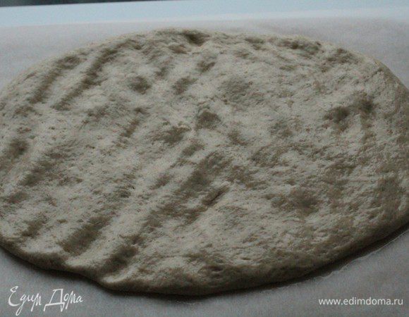 Выложить поднявшееся тесто на лист пергамента, смазанный маслом. Слегка обмять и сформировать руками прямоугольник.