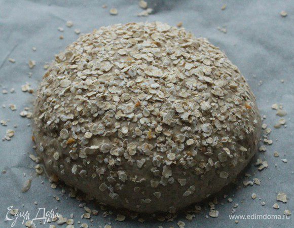 Обсыпать овсяными хлопьями и оставить еще на 1,5 часа. Готовое тесто должно пружинить при нажатии.