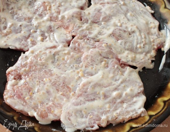 Смешать сметану с горчицей и измельченным чесноком, смазать отбитое мясо с двух сторон, накрыть крышкой, оставить на 20-30 минут.