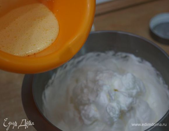 1/4 взбитых белков смешиваем с желтками, и так продолжаем порциями размешивать до конца.