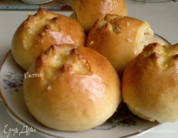 Противень застелем пергаментной бумагой, смазываем подсолнечным маслом. Из теста сформировать небольшие шарики, и сложить их в форму (противень) расстояние 2-3 см. Оставить пампушки на 10-20 минут для поднятия. Духовку разогреть до 180 С. Надрезать верхушки пампушек ножницами для красивой формы. Смазать пампушки желтком Смешанной с 1 ст.ложкой воды. Выпекать до золотистого цвета 30-40 минут.