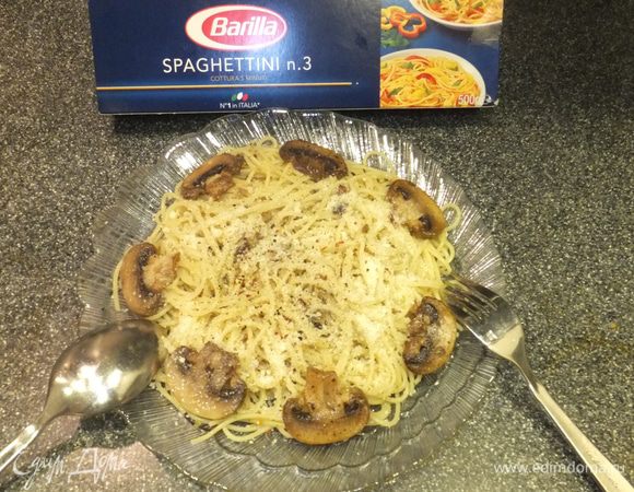 Выложите на тарелку спагетти, полейте соусом. Положите целые грибочки и посыпьте тертым пармезаном.