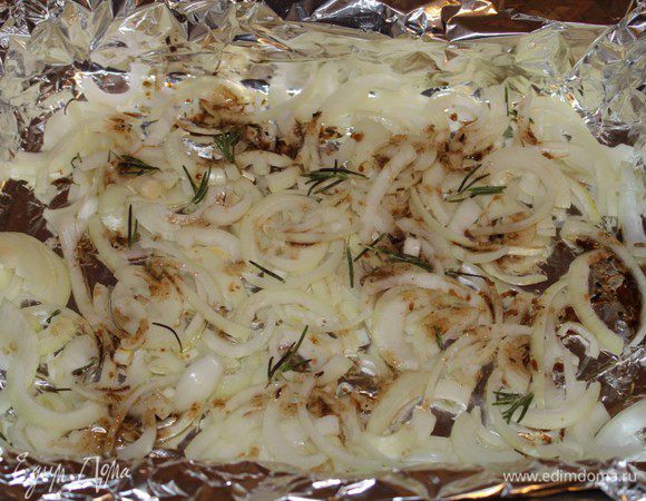 Глубокую форму для запекания выстелить фольгой. Две луковицы нарезать полукольцами, выложить в форму, посыпать листиками розмарина и сбрызгнуть заправкой.