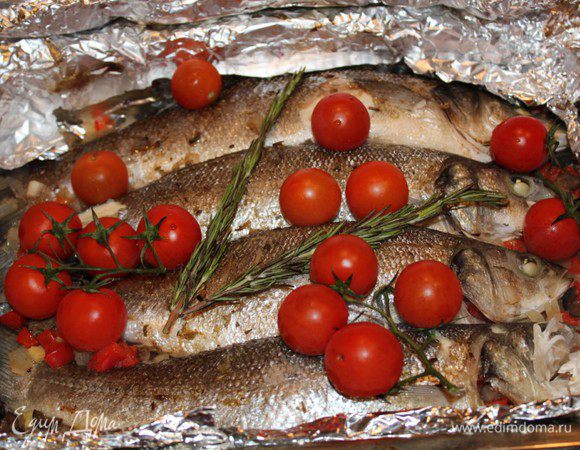 Запечь рыбу в разогретой до 200 градусов духовке в течение 15 минут. Затем достать, выложить на рыбу веточку розмарина и помидоры. Запекать еще 10 минут.