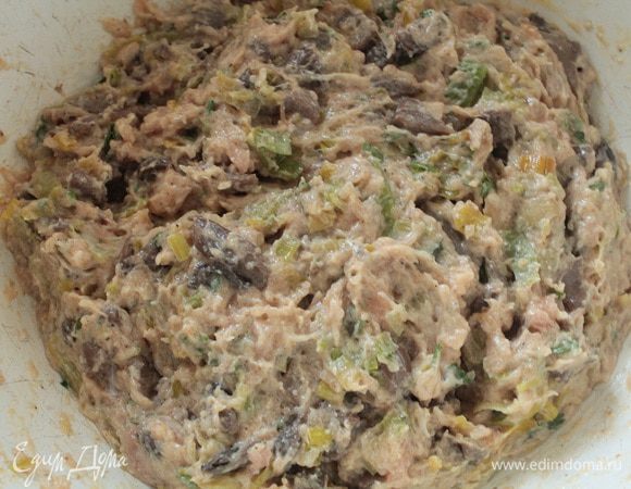 Приготовить фарш из срезанных кусочков мяса. С десяти ножек у меня получилось  200 граммов. Шампиньоны нарезать мелко, лук-порей полукольцами. В сковороде с растительным маслом обжарить шампиньоны до испарения жидкости, добавить лук-порей, перемешать и прогреть 2 минуты, остудить. Добавить к мясному фаршу. Добавить остальной сыр, желток одного яйца,столовую ложку белых панировочных сухарей, зелень петрушки и соль, перец по вкусу, хорошо перемешать.
