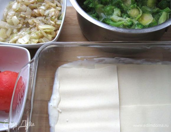 Форму смазать маслом. На дно формы положить часть соуса бешамель, разровнять. Положить листы лазаньи немного внахлест.