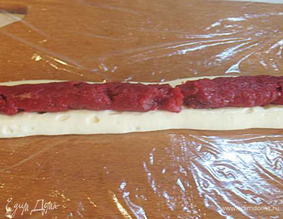 На стол постелить пищевую пленку. Крем и клубничный пудинг переложить в кондитерские мешочки по отдельности. На пищевую пленку насадкой 1,5 см выдавить две полоски крема длиной с бисквит. Сверху на середину крема выдавить полоску клубничного пудинга и накрыть его полосками крема.