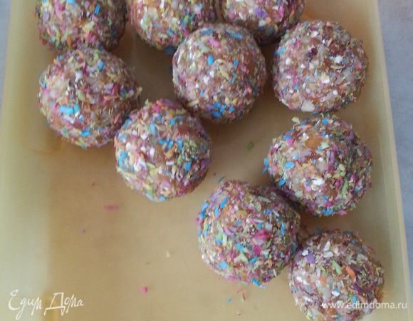 Смешиваем курагу, миндаль и 1/3 перемолотых хлопьев. Хорошо вымешиваем. Ставим чашу с прохладной водой для смачивания рук, а также чашу с кокосовой стружкой для обвалки. Хорошо смоченными руками берем фруктово-ореховую массу размером с чайную ложечку, вкладываем орешек, скатываем тугой шарик. Опускаем его в кокосовую стружку и аккуратно с помощью ложки обваливаем, переносим в емкость для охлаждения. И так по очереди делаем все миндальные конфетки. Пока они мокрые их легко обвалять в стружке. Убираем на 1-2 часа в холодильник.