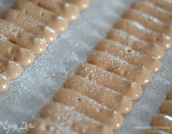 Меряем сантиметром размер нашей формы,ширину и длину,сделать это нужно до приготовления печенья , чертим карандашом на пергаменте нужные нам полоски,выдавливаем из кондитерского мешка небольшие палочки близко к друг другу,посыпаем обильно сахарной пудрой и выпекаем около 10 минут до готовности.