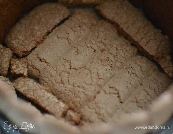 Достать из холодильника форму с савоярди и выложить плотно друг к другу низ бисквитным шоколадным печеньем. Пропитать его совсем слегка,