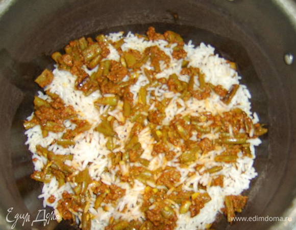 На дно кастрюли с толстым дном налить 2 ст.л. растительного масла без запаха и нагреть его, потом укладываем слоями рис и фасоль с фаршем: вначале небольшой слой риса, затем немного фарша с фасолью и тд. 