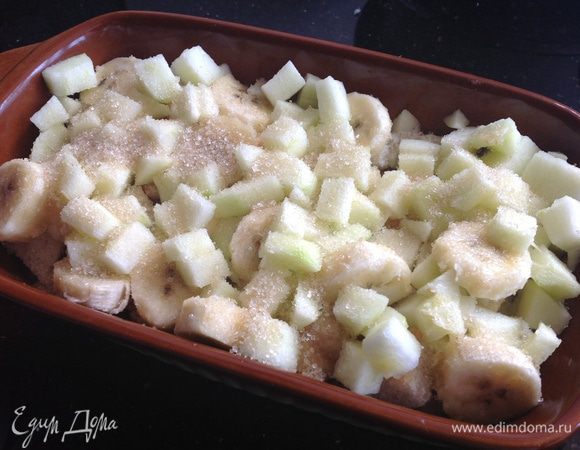 Распределите половину хлебных кубиков по дну огнеупорной формы. Сверху выложите яблоки и бананы.