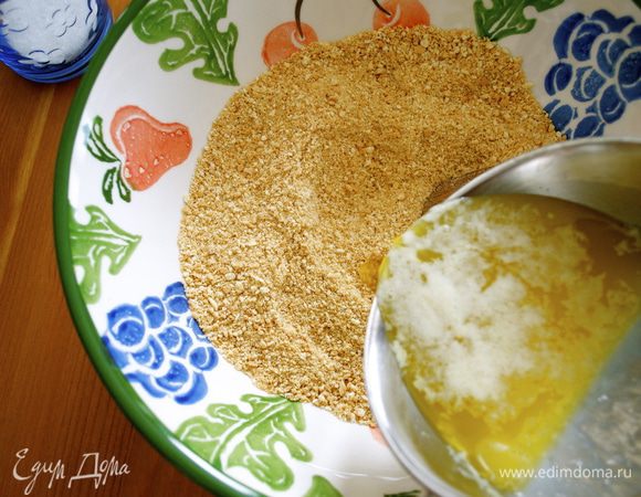 Первым делом печенье измельчить в блендере. Сливочное масло растопить, остудить и смешать с крошкой печенья. 