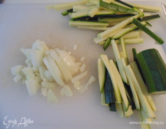 Креветки почистить, удалить кишечную вену. Небольшую луковицу мелко порезать. Цукини нарезать соломкой (вес двух цукини составил 230 грамм).
В сковороде разогреть оливковое масло, добавить лук, на небольшом огне обжарить 3 минуты, добавить цукини, огонь увеличить, обжарить 3 минуты, переодически помешивая.