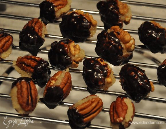 Окунать одной стороной орешки в глазурь. Выложить на решетку.