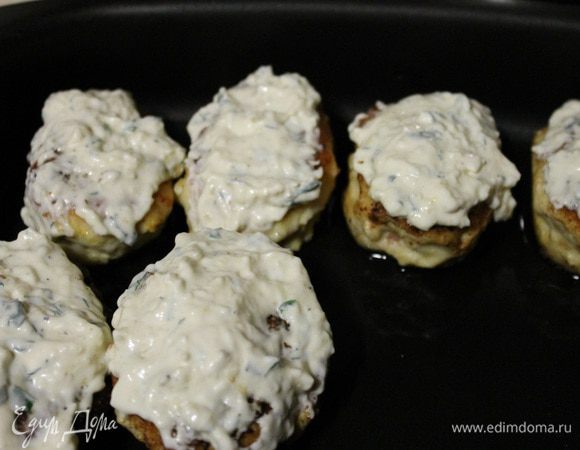 Для соуса: сыр натереть на крупной терке, чеснок пропустить через пресс, зелень мелко порубить, добавить сметану и майонез, посолить и поперчить по вкусу, все хорошенечко перемешать. И обмазать соусом наши котлетки. Запекать в заранее разогретой до 180 градусов духовке 15-20 минут.