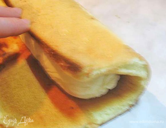 Достать крем из морозилки, снять пищевую пленку. Замороженный крем обернуть бисквитом. Вокруг крема должен быть один оборот бисквита.