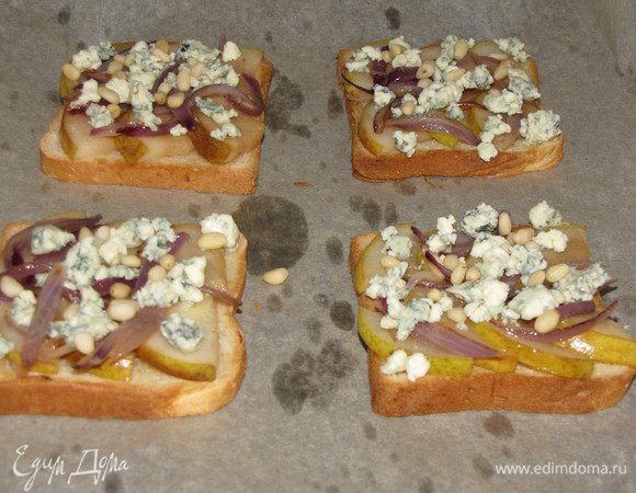 Посыпьте раскрошенным сыром и кедровыми орешками. Снова поставьте тосты под гриль и готовьте, пока сыр не начнет плавиться, 2-3 минуты.