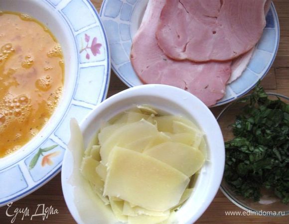 Помыть, обсушить базилик. Мелко порезать 1 веточку базилика.  Сыр тонко порезать лепестками с помощью овощечистки. Перемешать яичную смесь.