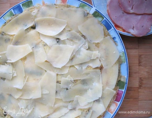 Распределить сверху по всей плоскости омлета лепестки сыра. 