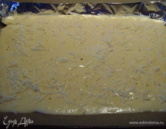 Вылить тесто на противень, посыпать 1/4 пармезана и выпекать около 15 мин. 