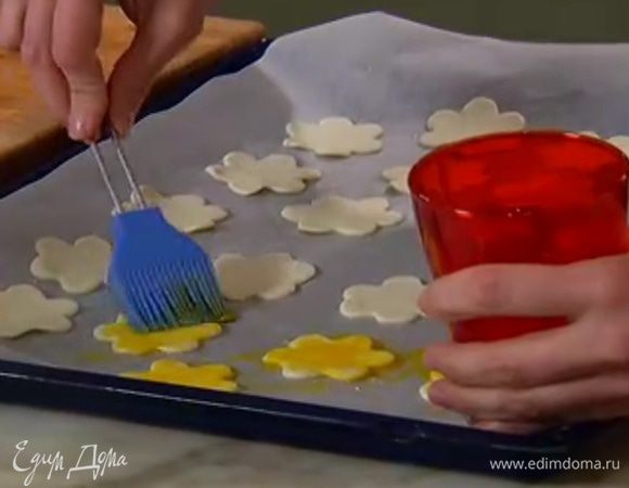 Желток слегка взбить со щепоткой соли и смазать тесто.