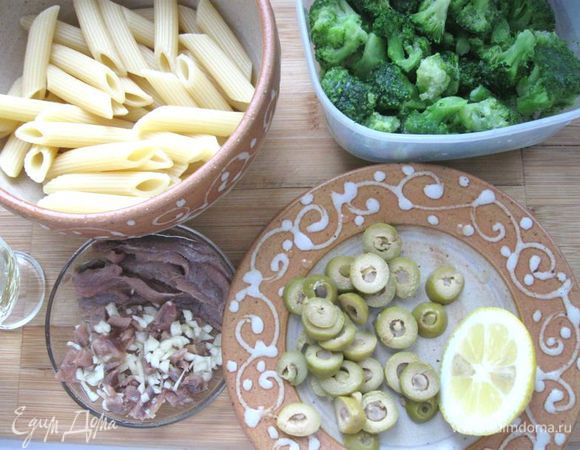 Чеснок почистить, мелко порезать.  Три штуки филе анчоусов порезать на кусочки. Разделить брокколи на соцветия, обрезать черешки. Оливки порезать на колечки. Отварить пасту в  кипящей подсоленной воде в течение 11 минут (как указано на упаковке). Откинуть на дуршлаг, немного ополоснуть холодной водой.


