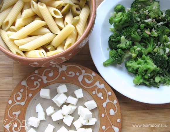 На раскаленную сковороду с оливковым маслом выложить порезанное филе анчоусов и чеснок, подержать 1 минуту, помешивая. Положить капусту в кастрюлю с  подсоленной кипящей водой  и варить 1 минуту. Достать брокколи из воды, откинуть на дуршлаг и добавить к анчоусам на сковороду. Тушить на сковороде  примерно 1 минуту (если взять свежую капусту брокколи,  время надо увеличить до 5 – 6  минут). Снять с огня, посолить, поперчить, дать остыть. Моцареллу нарезать кубиками, соединить пасту с капустой, моцареллой, оливками, перемешать.