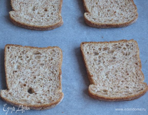Выложить хлеб на противень с пергаментом и поставить в разогретую до 200 °С духовку под гриль на несколько минут.