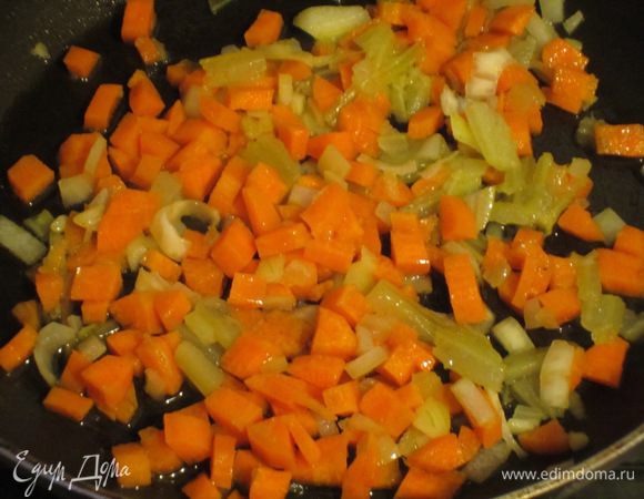 Разогреть в сковороде оливковое масло и обжарить сельдерей, морковь и лук на слабом огне 10 минут.