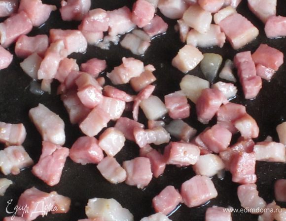 Бекон нарезать кубиками и обжарить  на сухой сковороде .