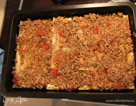 Взять форму, смазать оливковым маслом Buglioni, выкладывая листы внахлест, сверху сырный соус, затем томатный соус и продолжать слоями, в  той же последовательности.