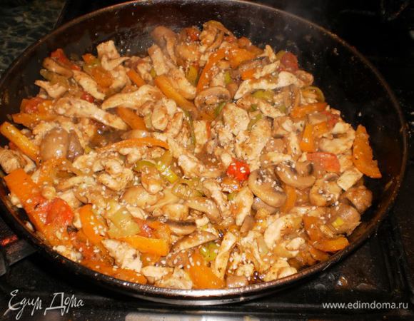 Затем добавляем курицу, посыпаем солью, приправами и кунжутом. Выдавливаем чеснок.