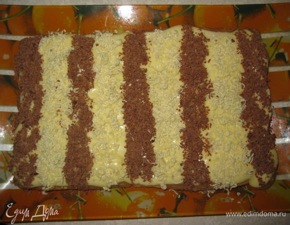 Затем чайной ложкой выкладываем черные и белые полоски, тертым на мелкой терке, шоколадом. Я взяла обычный лист бумаги, чтобы они были ровными.