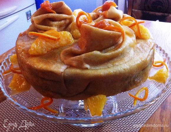 Перед подачей приготовим абрикосовую глазурь: 
Нагреваем абрикосовый джем до жидкого состояния, добавляем воды и доводим до кипения. Снимаем с огня и даем немного остыть. 
Торт вынимаем из формы и убираем пленку. 
Укладываем на свое усмотрение отложенные блины сверху торта. Смазываем со всех сторон глазурью и украшаем апельсиновыми дольками. 
Либо украшаете на свой вкус и в зависимости от вашей фантазии.
Приятного аппетита и вкусной масленицы!!!