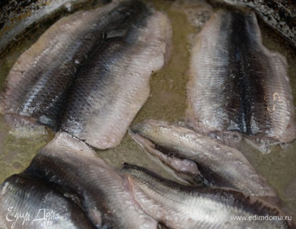 Почистить анчоусы и вынуть из них косточки. На среднем огне разогреть в глубокой сковороде половину масла и выложить анчоусы. Аккуратно обжарить их и измельчить.