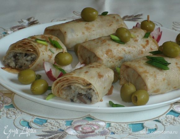 Выложить начинку на блины, свернуть конвертиками.